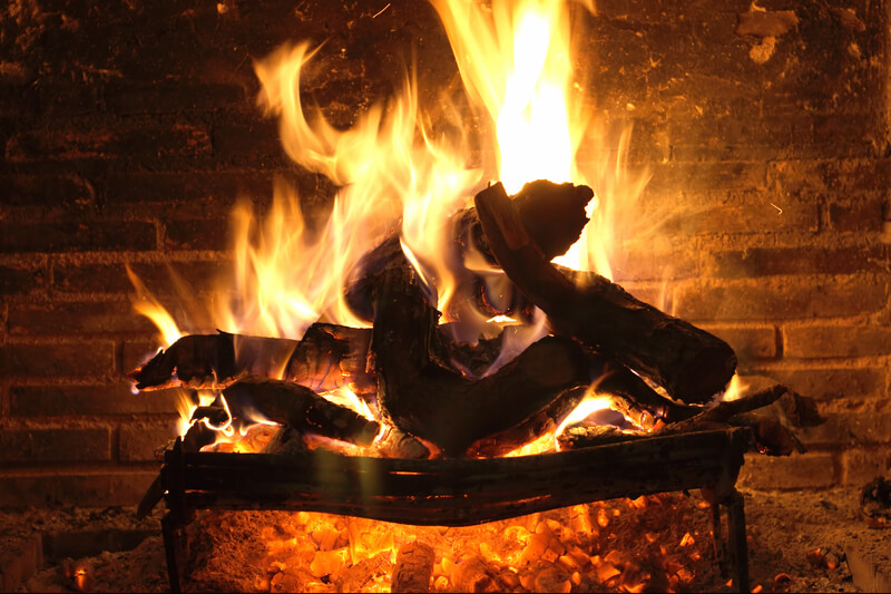 Close up image of an open Fireplace burning wood.